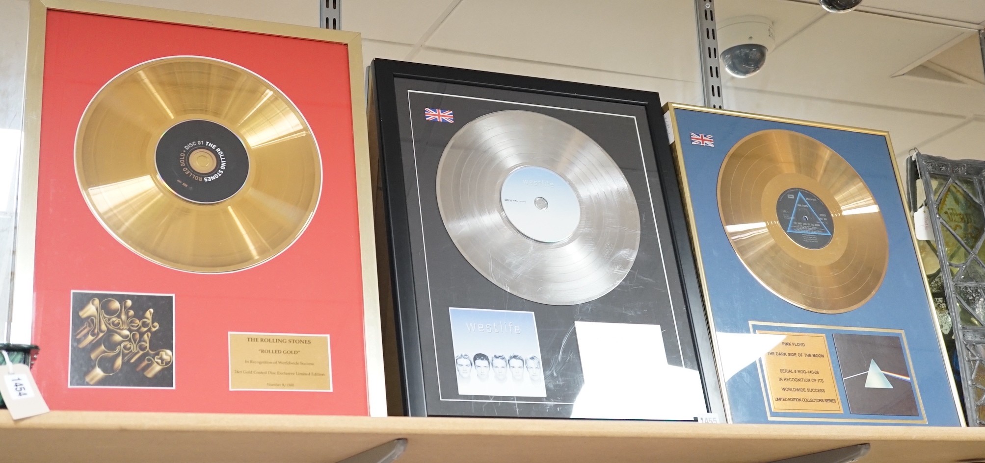 Three glazed framed award winning records: Pink Floyd, The Rolling Stones and Westlife
